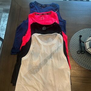 4 women’s size large Nike running tanks. They are slightly cropped. Never worn
